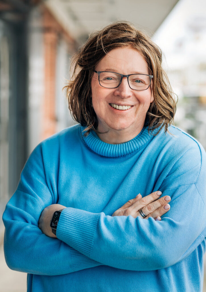 Ein Portrait der Geschäftsführerin mit hellblauem Pulli.